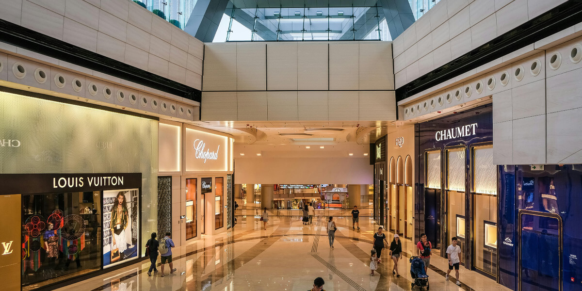 Mall interior with marbled flooring with multiple shops and outlets