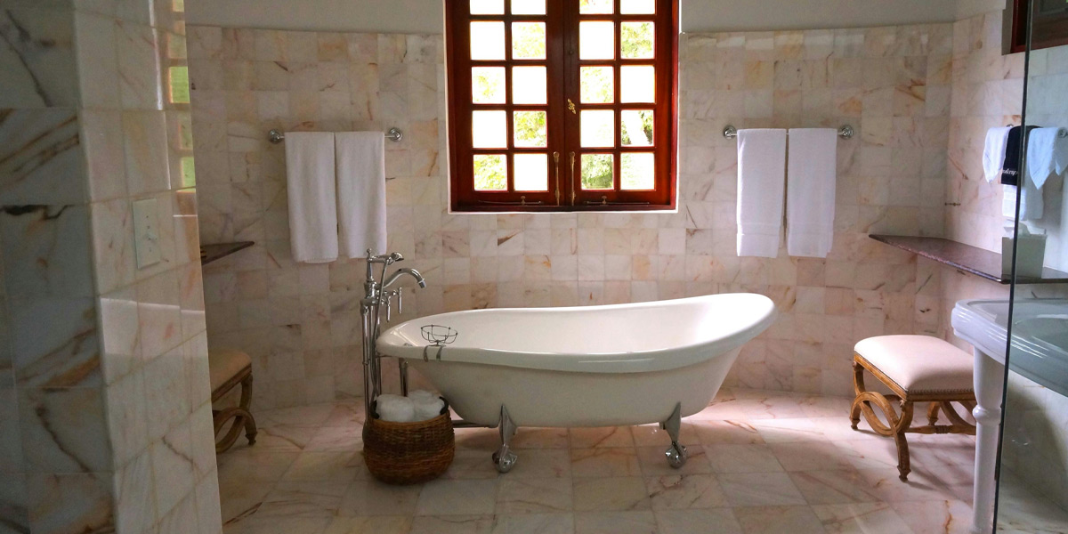 Modern bathroom design featuring marbled tiles and flooring, with a movable bathtub