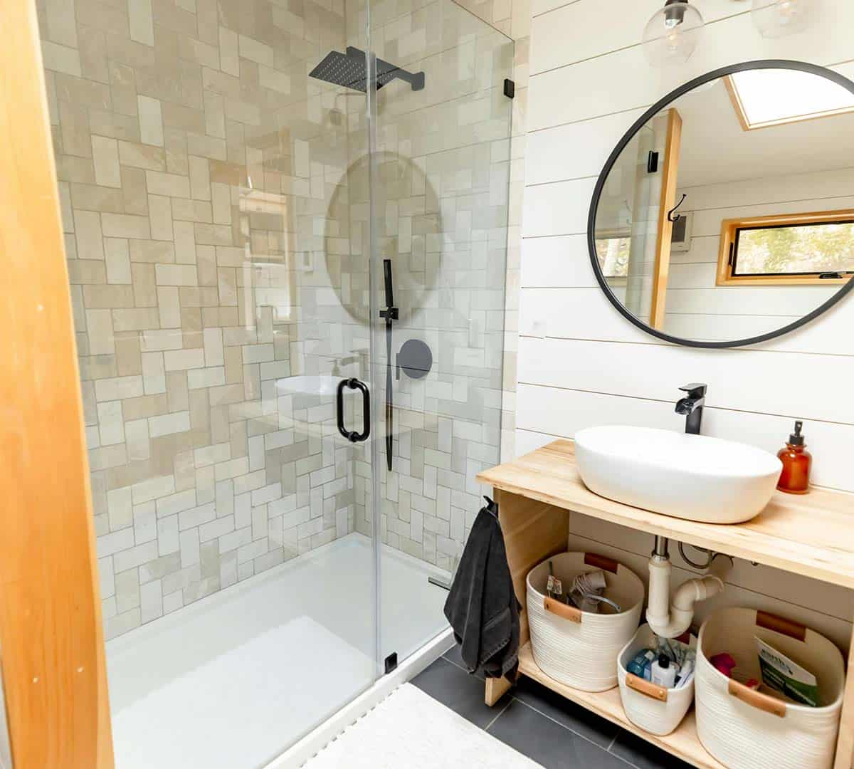 Modern bathroom interior with a glass partition dividing the shower area and a small vanity