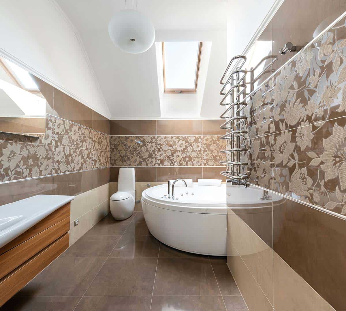 a latest designed bathroom with flowered tiles and brown floor, featuring a bathtub and commode