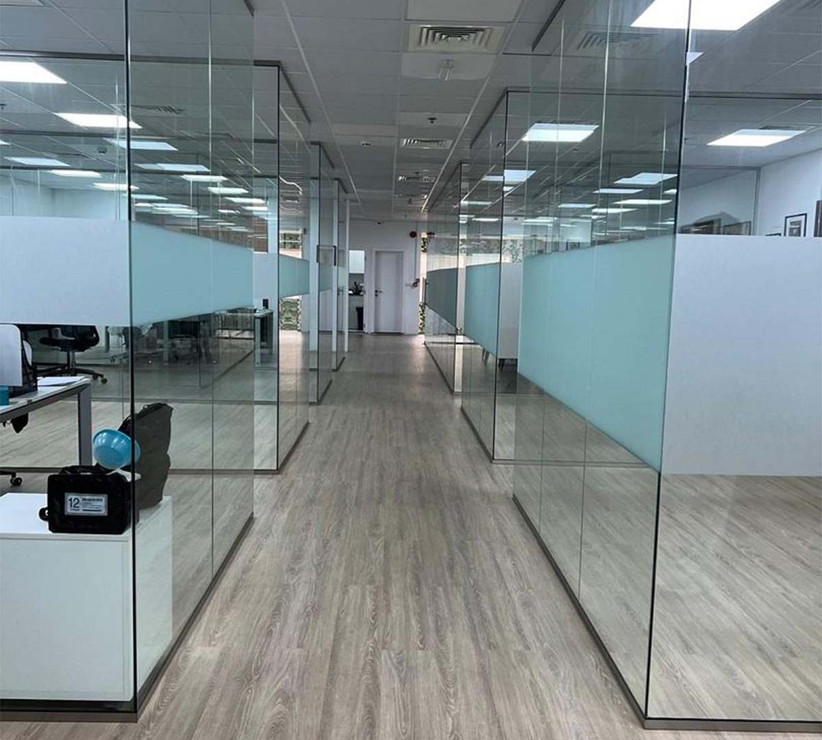 Multiple glass partitions creating separate workspaces on an office floor